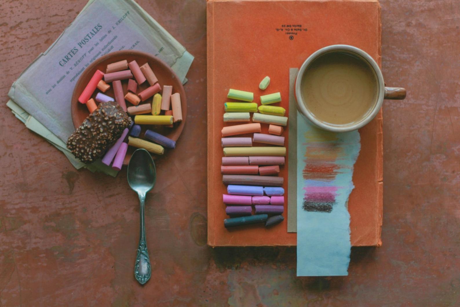 Gruppenarbeit im Kunstatelier mit verschiedenen Farbexperimenten auf dem Tisch